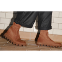 Tan suede lug sole boots with cropped dark trousers on tiled floor